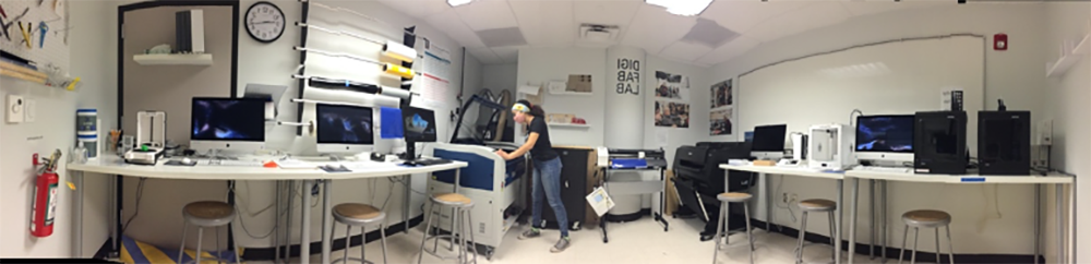 Wide-screen photo shot of DigiFabLab including Laser Cutter, 3D printers, large format digital printer, and computer workstations.