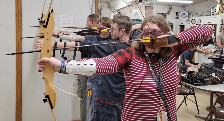 students with bows drawn at the archery lanes